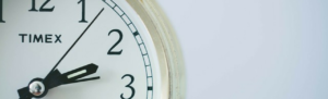 Up-close shot of minute hands on time clock for time management.