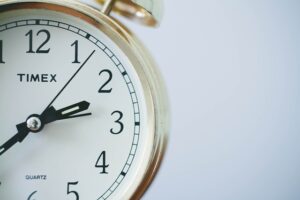 Up-close shot of minute hands on time clock for time management.