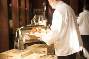 A member of catering staff uses Fingercheck to record their hours while serving customers.