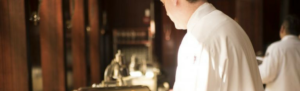 A member of catering staff uses Fingercheck to record their hours while serving customers.