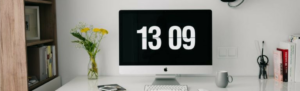 Time clock screensaver on computer within a home office.