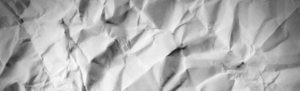 Crumpled up paper background representing wasted paper with traditional time clock systems.