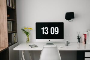 Time clock screensaver on computer within a home office.