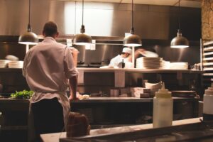 Kitchen staff preparing food clocked in using fingerprint time clocks for restaurant employees.