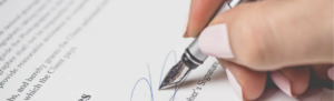 Person Holding Silver Pen Signing Employer's Signature, which never happens at FingerCheck which operates contract-free.