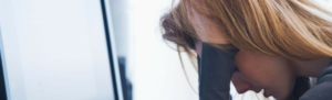 Stressed out female employee reflects how employee motivation and stress correlate.