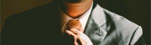 Candidate suiting up for big interview, close-up of tie being knotted.