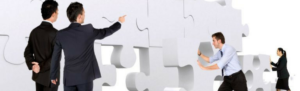 Employees use teamwork to build a puzzle, symbolizing employee engagement.