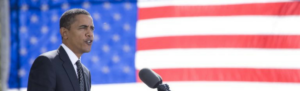 President Obama announcing new proposed overtime rule with American flag in background.