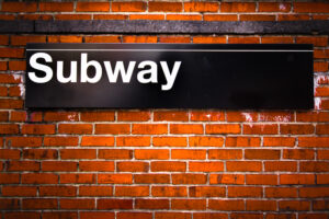 New York City subway stop sign signifying tax break for commuting expenses.