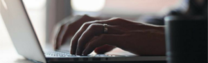 Businessman's hands typing purchase biometric time clock directly within Fingercheck account.