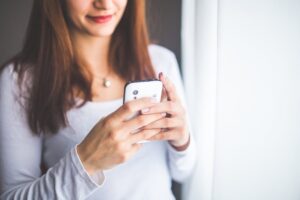 Woman uses smartphone to view the latest updates made to the Fingercheck mobile app.