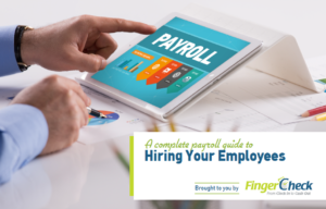 Businessman's hands tapping tablet with Payroll Guide for hiring new employees open.