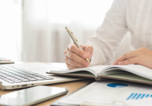 Businessman recording data to create a business general ledger of monthly expenses and transactions.