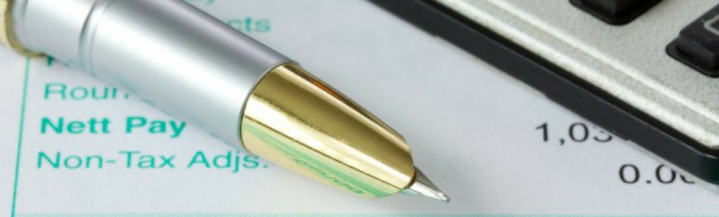 Calculator, payroll reconciliation figures and pen.