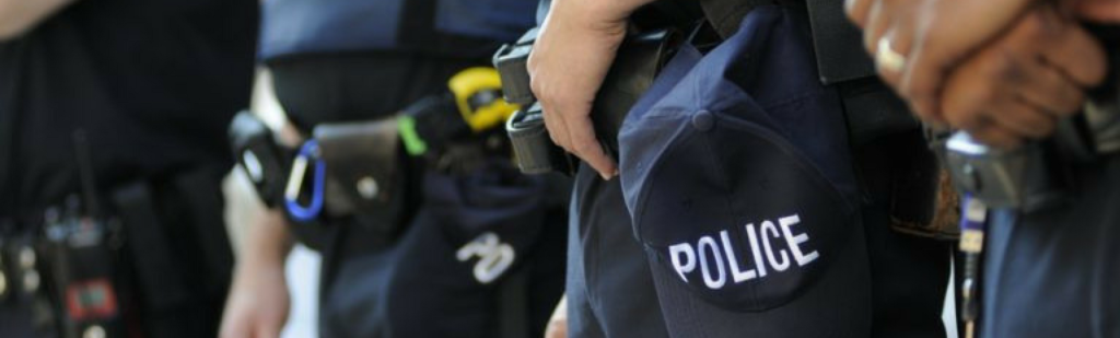 Detroit police officers somberly lined up in full uniform, expressing opposition to new time clock system.