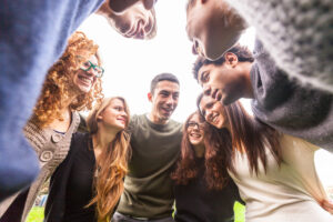 Teamwork, employees in huddle, playing March Madness-inspired team building game.