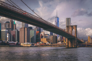 New York's Brooklyn Bridge with skyline beyond the horizon.