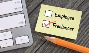 Sticky note with the word "Freelancer" box checked to symbolize new freelancer tax form generated during Fingercheck onboarding.