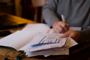 Payroll specialist sits with pile of paperwork.