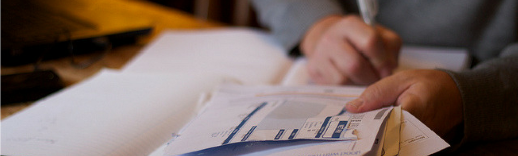 Payroll specialist sits with pile of paperwork.