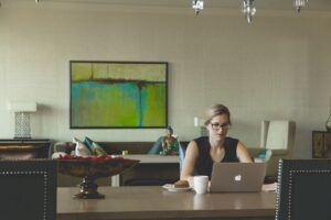 Remote employee works from home with laptop and breakfast.