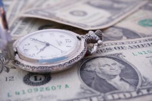 Stopwatch on dollar bills conveying concept of time and money intertwined.