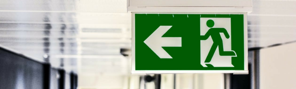 Airport terminal sign showing figure running with arrow represents employee running towards comp time.