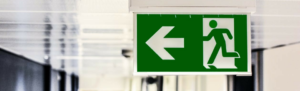 Airport terminal sign showing figure running with arrow represents employee running towards comp time.