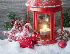 Beautiful red lantern with star Christmas ornaments in snow, lighting the way for small business owners to heed Fingercheck holiday tips.
