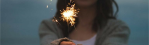 Girl holds sparkler in celebration of the New Year.
