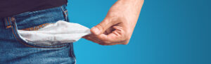 Empty pockets pulled out of man's jeans, signifies spending tax refund.