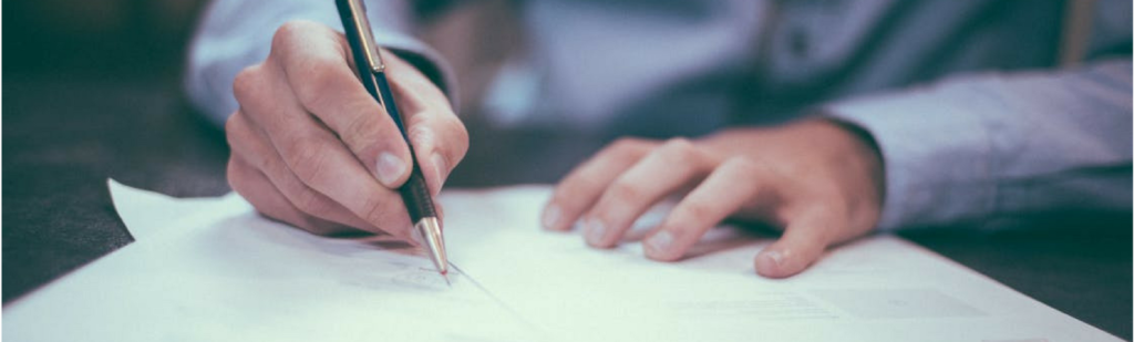 Independent contractor signing a contract deal confirming his hire agreement and worker classification.