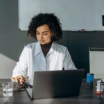 Healthcare administrator reviewing staffing schedule and labor costs on laptop