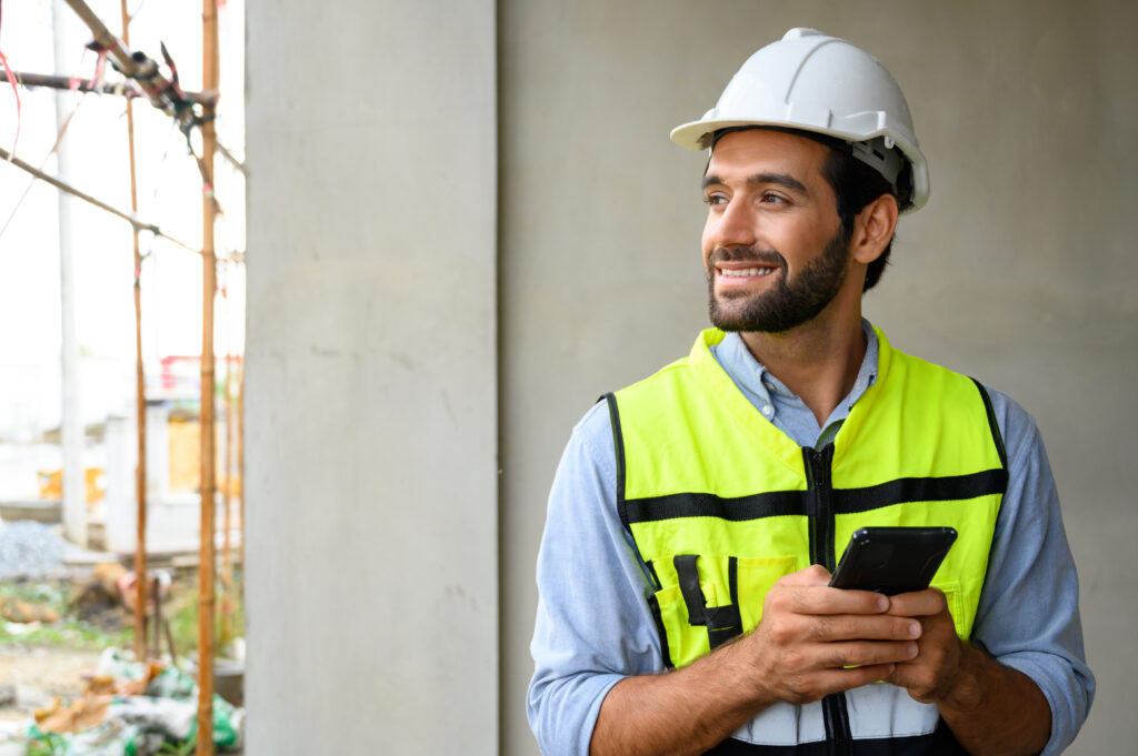 Construction worker smiling from paycheck received on his schedule