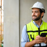 Construction worker smiling from paycheck received on his schedule