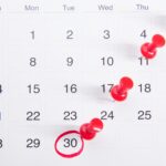 Calendar schedule with weekly days marked with pushpins.