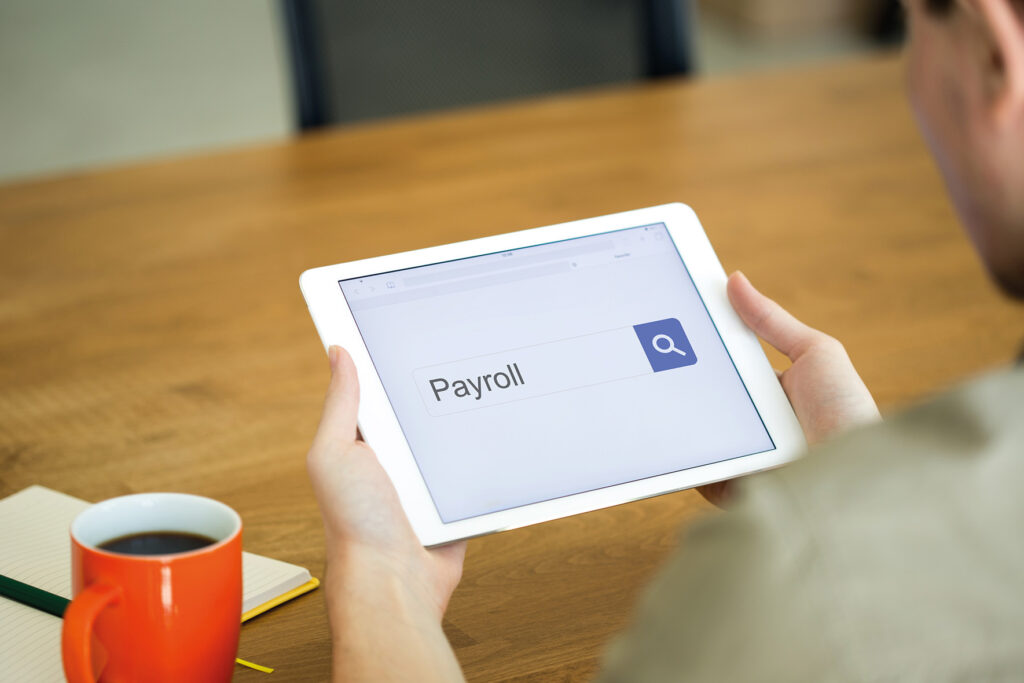 Business owner searching for payroll on a tablet
